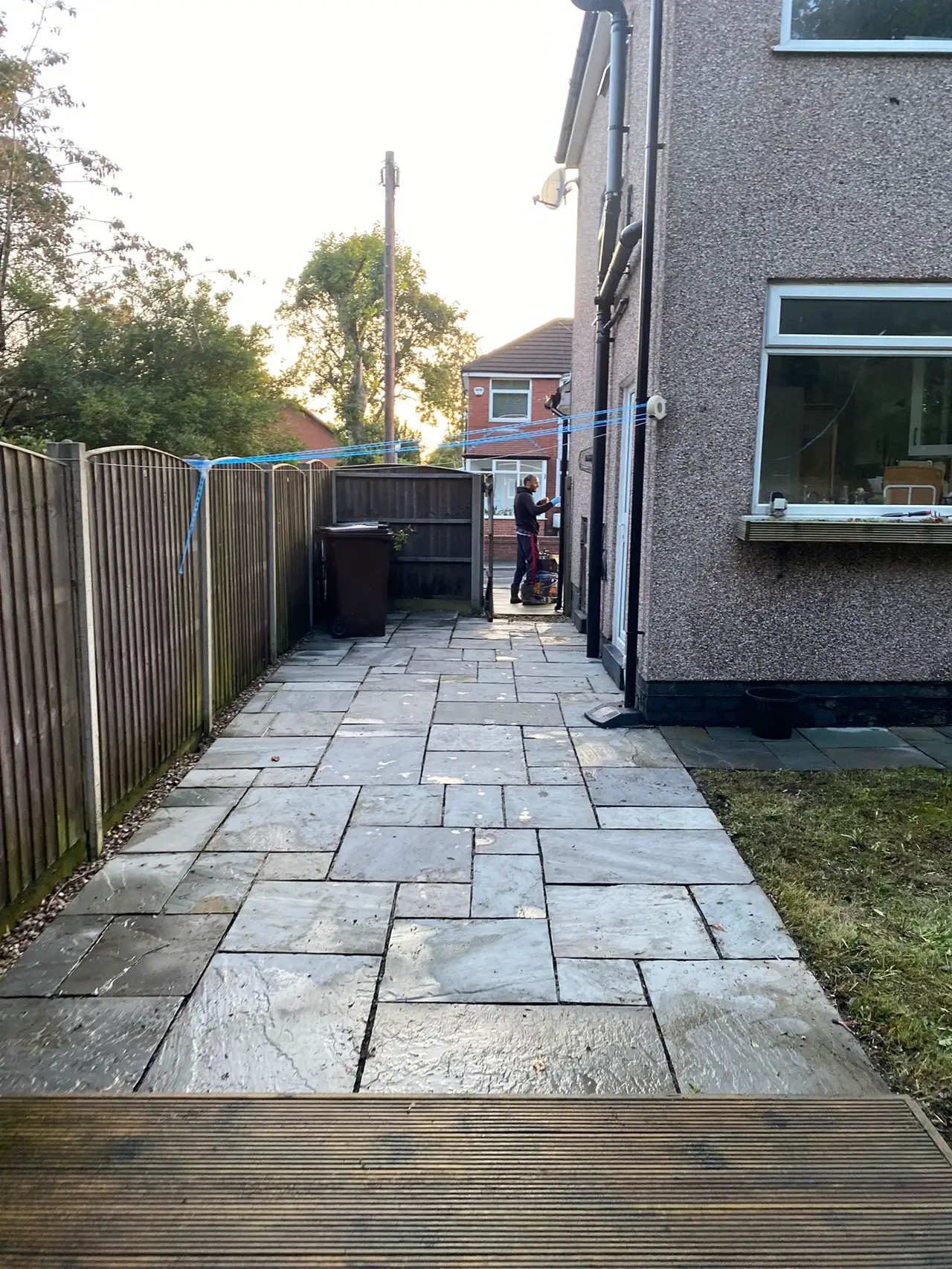 A clean new grey sandstone path Emad laid alongside a Greater Manchester home